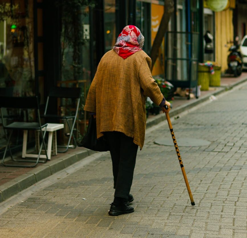 elderly woman walking down quaint streets