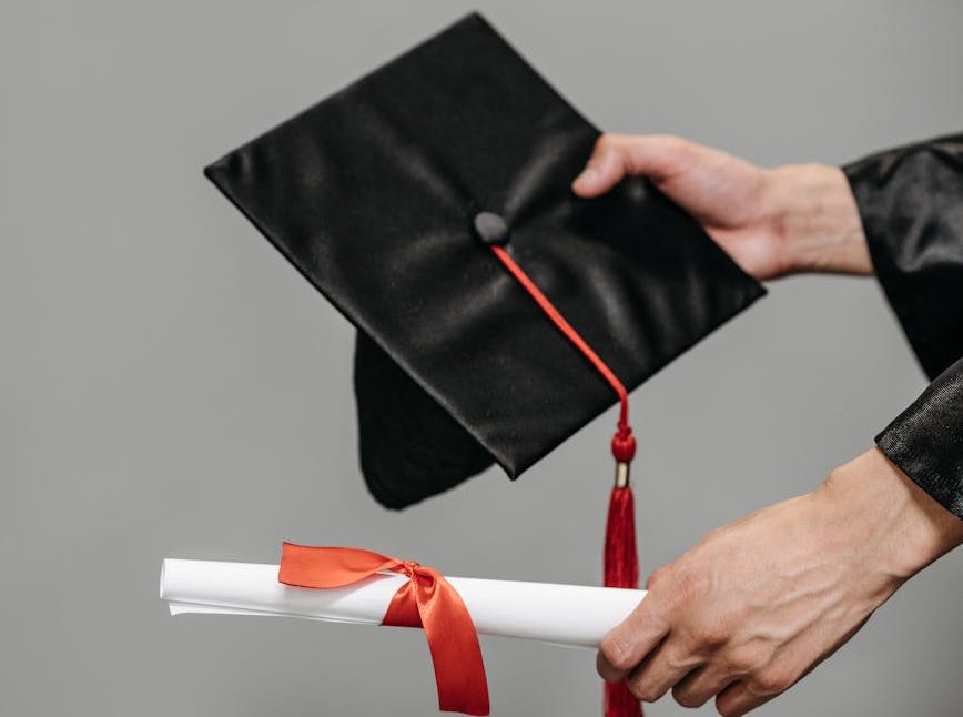 photo of person holding black academic hat