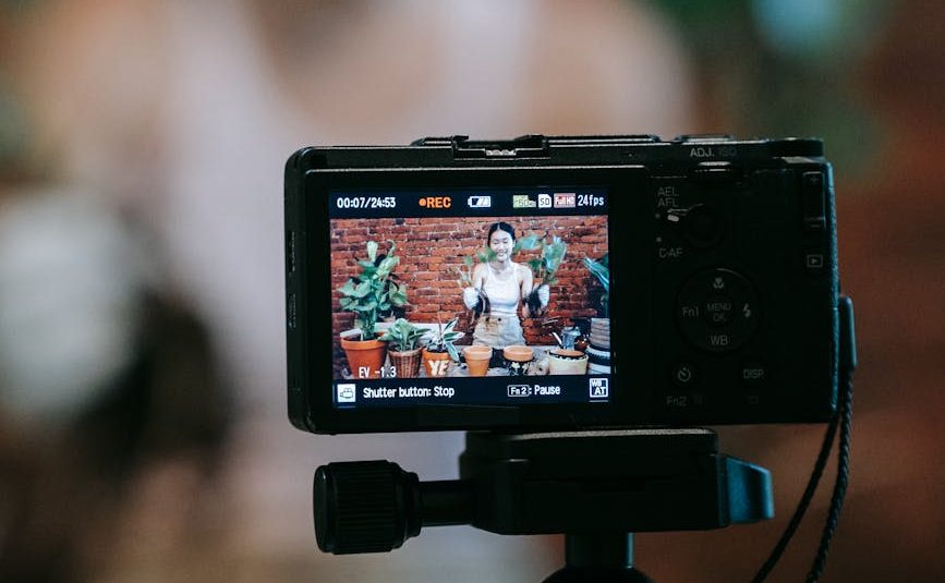 woman recording herself while holding her potted plants